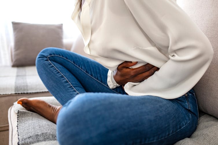 A woman clutching her stomach.